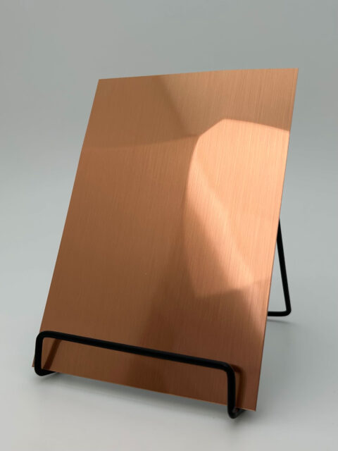 Dipslay stand with a copper brushed design panel whose structure is reminiscent of hammer blows.