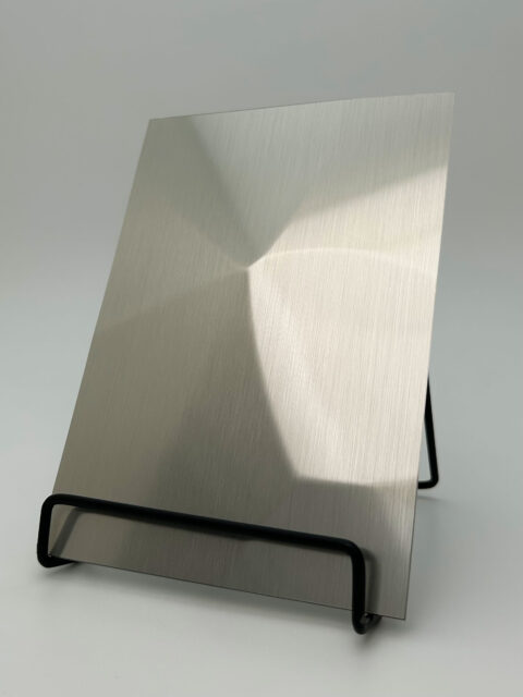 Dipslay stand with a silver reflective design panel whose structure is reminiscent of diamonds.