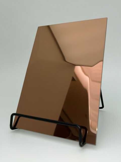 Dipslay stand with a copper reflective design panel whose structure is reminiscent of hammer blows.