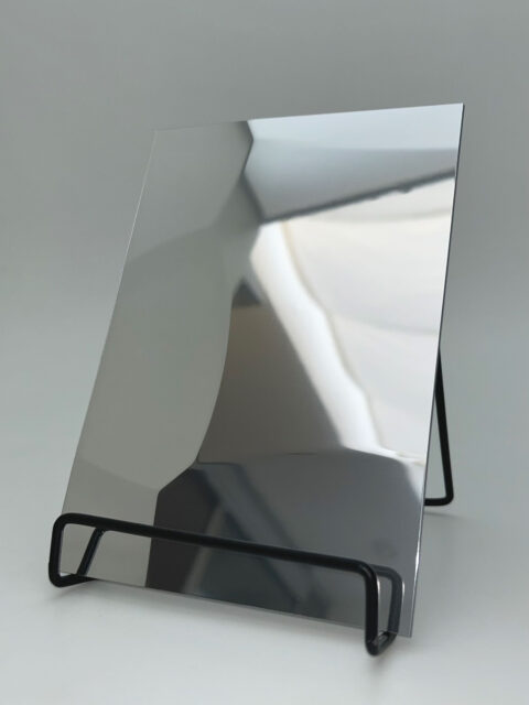 Dipslay stand with a silver reflective design panel whose structure is reminiscent of hammer blows.