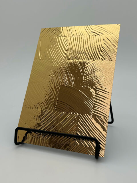Display stand with a design panel. The structure is checkered, glossy, and gold in color.