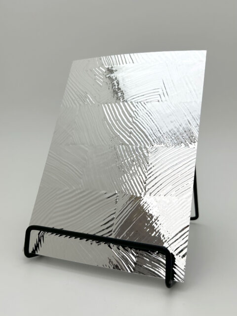 Display stand with a design panel. The structure is checkered, glossy, and silver.