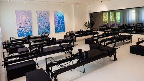 Modern gym with black equipment and white walls with large reflective images on the wall.