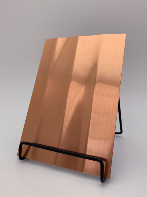 Display stand with a brushed copper design panel, whose structure is characterized by broad vertical lines. The heights and depths of the structure create a particularly deep effect that is impressive.Display stand with a brushed copper design panel, whose structure is characterized by broad vertical lines. The heights and depths of the structure create a particularly deep effect that is impressive.