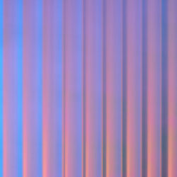 Detailed shot of a designer panel with a structure characterized by broad, vertical lines. The surface is reflective, and the color ranges from blue to pink depending on the viewing angle. The heights and depths of the structure create a particularly deep, captivating effect.