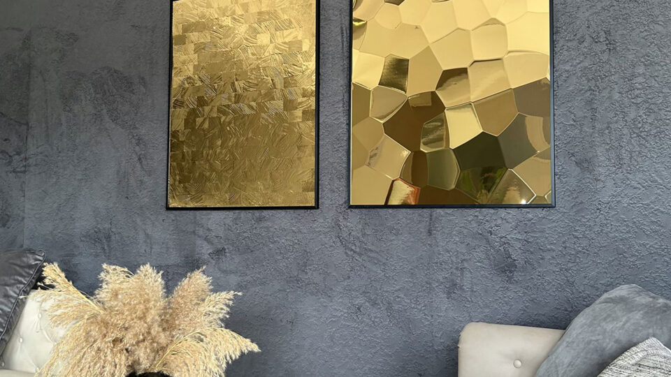 Mirrored design panel on the wall in a frame with a hammered finish - golden color.