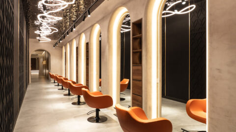 Treatment area of a beauty salon with a dark reflective ceiling.