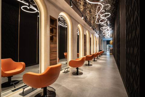 Treatment area of a beauty salon with a dark reflective ceiling and a light-colored floor