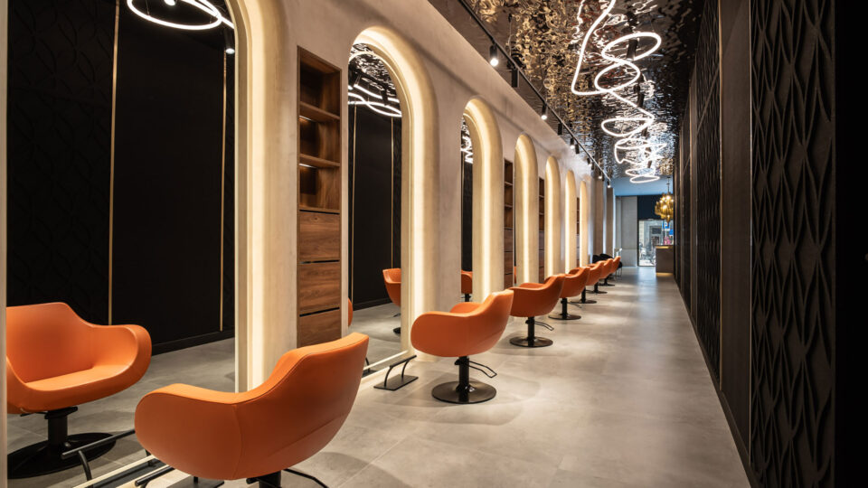 Treatment area of a beauty salon with a dark reflective ceiling and a light-colored floor