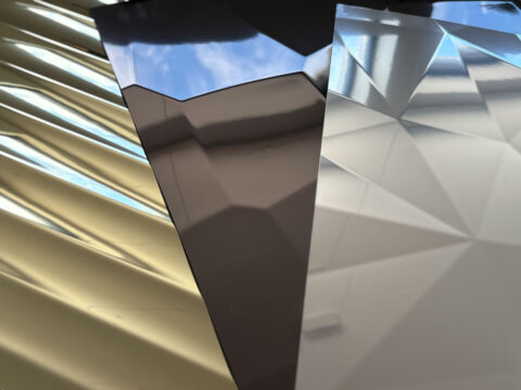 Three structured, reflective product patterns by SIBU DESIGN: the first in light gold with a modern interpretation of antique vertical columns, the second in anthracite resembling a hammered surface, and the third in silver reminiscent of a diamond cut.