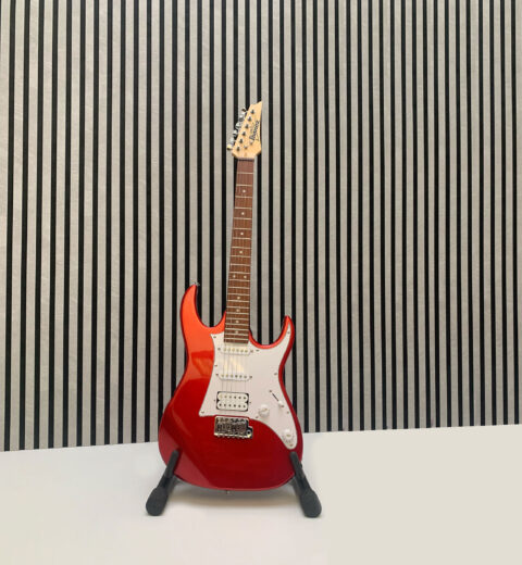 Black and white background with a red electric guitar in the foreground