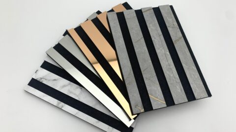 Acoustic panels fanned out on a white table, showcasing stylish and varied material combinations.